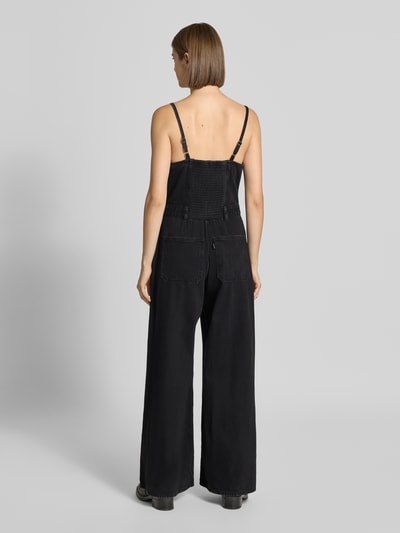 Kobieta modelka nosi czarny kombinezon Regular Fit Jumpsuit aus reiner Baumwolle model 'SEAMED' od Levi's® 300, widok całej sylwetki z tyłu.