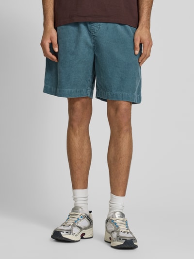 Mannenmodel draagt korte jeans van puur katoen relaxed fit model 'Reynold' van Carhartt Work In Progress, vooraanzicht, binnenbeenlengte maat M 18 cm, bandwijdte maat M 41 cm.