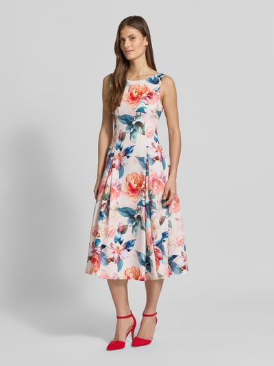 Frauenmodel trägt Cocktailkleid im Allover-Look mit gelegten Falten von Vera Mont, Material-Mix mit Stretch-Anteil, A-Linie, Midikleid, Rundhalsausschnitt, florales Muster in Pastellfarben, Ganzkörperansicht von vorne.