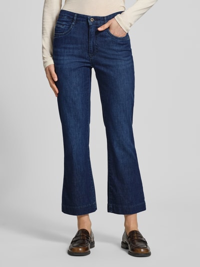 Frauenmodel trägt Bootcut Jeans im 5-Pocket-Design Modell 'Mary' von Brax aus Baumwoll-Mix mit Stretch-Anteil, dunkelblau, Nahaufnahme Oberkörper bis Füße, Damen Bootcut Jeans Kontext.