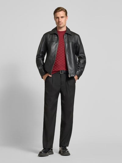 Männermodel trägt Strickshirt mit Struktur-Muster von Antony Morato in Rot, kombiniert mit schwarzer Hose und Lederjacke, Ganzkörperansicht von vorne, Herren Strickshirt von Antony Morato, Lyocell-Woll-Mix, gerader Schnitt, Rundhalsausschnitt, Rückenlänge bei Größe M 72 cm.