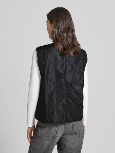 Vrouwenmodel draagt Regular fit bodywarmer met eenrijige knoopsluiting Model 'MILLIE' van Vero Moda, look: effen, doorgestikte materiaalverwerking, steekzakken, volledig zwarte tint, rugaanzicht.