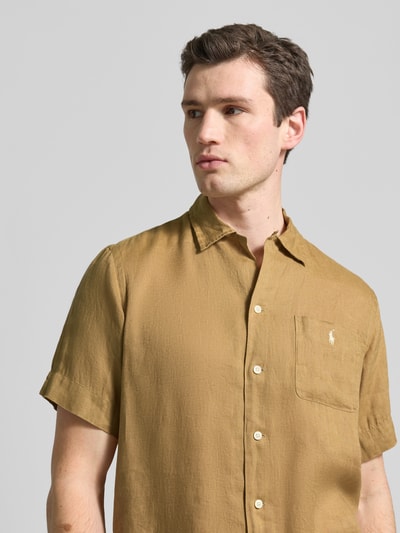 Männermodel trägt Regular Fit Freizeithemd aus reinem Leinen von Polo Ralph Lauren, unifarben, kurzarm, mit Brusttasche, Nahaufnahme Oberkörper.