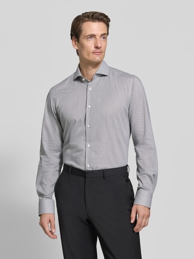 Männermodel trägt Slim Fit Businesshemd aus reiner Baumwolle Modell 'HANK' von BOSS, grau mit feiner Struktur, Ganzkörperansicht von vorne, Herren Businesshemd von BOSS.