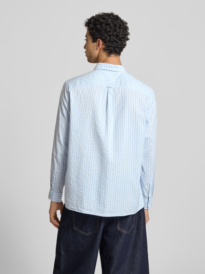 Männermodel trägt Relaxed Fit Freizeithemd aus Baumwoll-Modal-Mix von Tommy Jeans mit Allover-Muster in Blau und Weiß, Ganzkörperansicht Rückansicht.