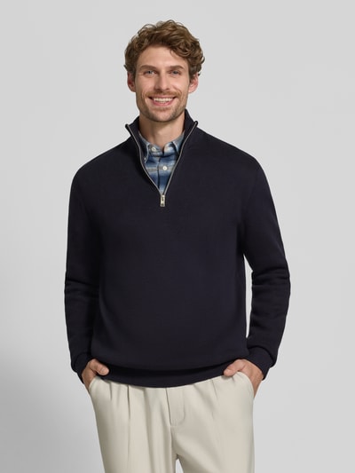 Männermodel trägt Slim Fit Pullover aus reiner Baumwolle Modell 'MILANO' von JACK & JONES Premium, dunkle Farbe, Strick-Optik, Troyer-Kragen, Nahaufnahme Oberkörper.