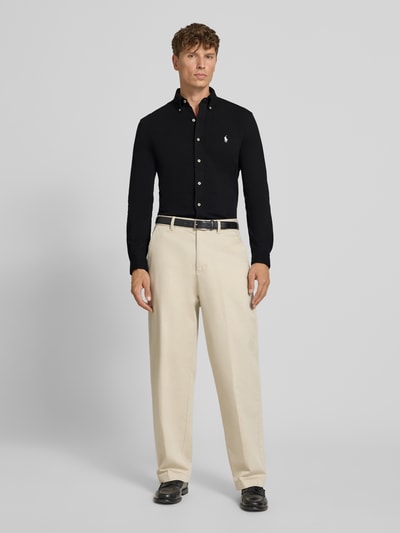 Männermodel trägt Regular Fit Freizeithemd aus reiner Baumwolle von Polo Ralph Lauren in Schwarz, beige Hose, Ganzkörperansicht von vorne.