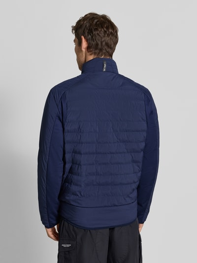 Mężczyzna nosi Regular Fit Sweatjacke mit Steppung od Polo Ralph Lauren, ciemnoniebieska, struktura pikowania, widok całej sylwetki z tyłu.