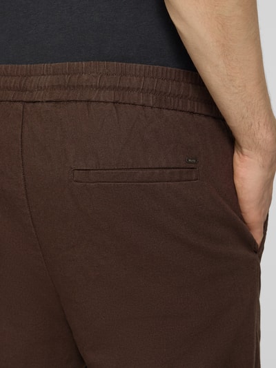 Männermodel trägt Tapered Leinenhose aus Baumwoll-Leinen-Mix Modell 'LINUS' von Only & Sons, Optik: Unifarben, Detailaufnahme Rückansicht.