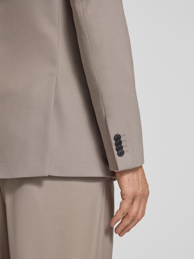 Männermodel trägt Regular Fit Anzugsakko mit Viskose-Anteil Modell 'Karlo243X' von HUGO in Beige, Twill-Struktur, Detailaufnahme Arm und Ärmelabschluss