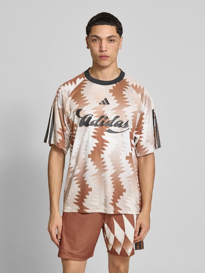 Männermodel trägt Regular Fit T-Shirt mit Allover-Muster von adidas Sportswear, Label-Print, Rundhals, Kurzarm, Ganzkörperansicht von vorne.