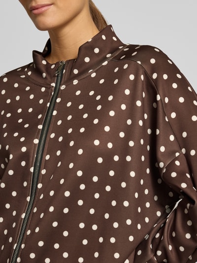 Frauenmodel trägt Jacke im Allover-Look Modell 'Is44ina' von ZABAIONE, braun mit weißen Punkten, Reißverschluss, Nahaufnahme Oberkörper. Material-Mix mit Stretch-Anteil, Regular Fit, Stehkragen.