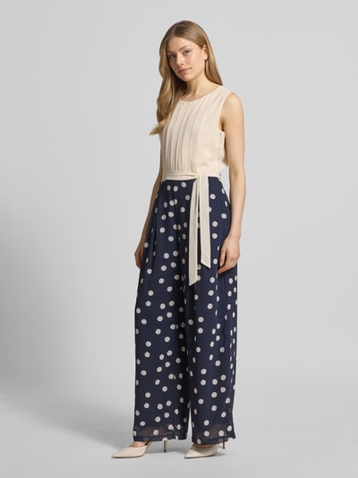 Vrouwenmodel draagt Regular Fit Jumpsuit mit Taillengürtel zum Binden van s.Oliver BLACK LABEL, meerkleurig, gestippeld, chiffon, boothals, mouwloos, ritssluiting. Ganzkörperansicht van voren.