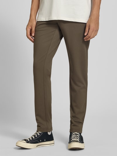 Männermodel trägt Slim Fit Chino aus Viskose-Mix Modell 'MARK' von ONLY in Braun, glatte Oberfläche, Herren Chino von ONLY, Nahaufnahme Unterkörper, Ganzkörperansicht von vorne.
