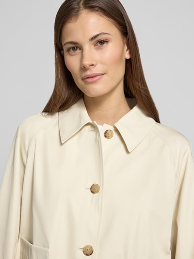 Kobiece modelka nosi Relaxed Fit Trenchcoat aus reiner Baumwolle od Tommy Hilfiger, efekt: jednolity kolor, krój relaxed fit, wykładany kołnierz, listwa guzikowa, krój krótki, detal z logo, zakończenie rękawów proste, hydrofobowy, splot twill, bawełna; zbliżenie na górną część ciała, widok z przodu.