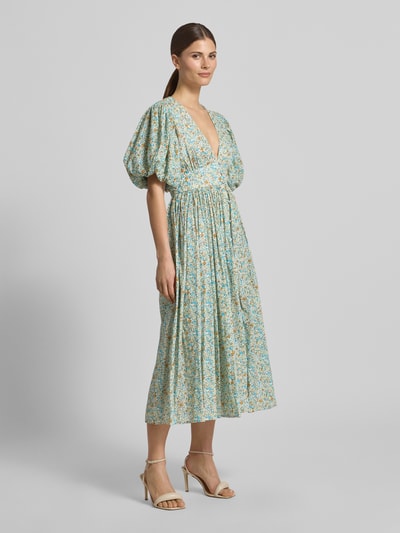Frauenmodel trägt Cocktailkleid mit V-Ausschnitt und Puffärmeln von LACE & BEADS aus reiner Baumwolle, A-Linie, Midikleid, Ganzkörperansicht von vorne.