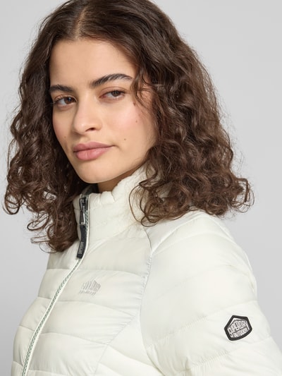 Vrouwenmodel draagt Steppjacke met Logo-Stitching Modell 'FUJI' van Superdry in recht model, staande kraag, detailopname schouder en borst.