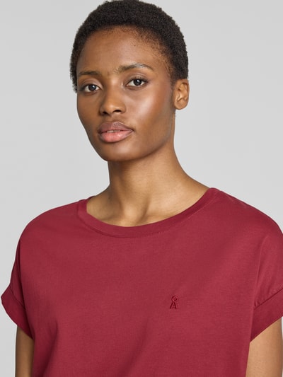 Frauenmodel trägt dunkelrotes Loose Fit T-Shirt aus reiner Baumwolle Modell 'IDAARA' von ARMEDANGELS, Damen T-Shirt, Nahaufnahme Oberkörper.