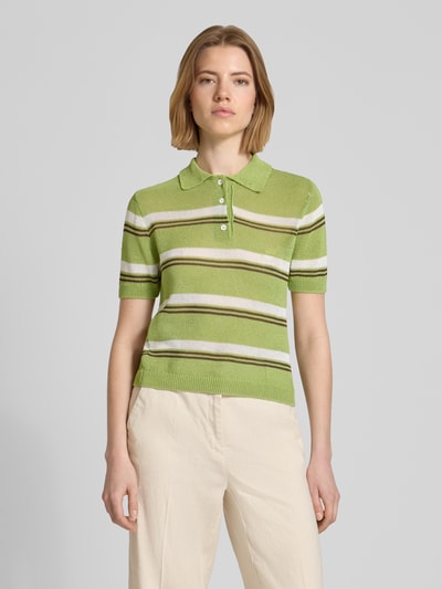 Frauenmodel trägt Slim Fit Poloshirt in Strick-Optik Modell 'Verdi' von Mango in Grün mit Streifen, Material-Mix, Nahaufnahme Oberkörper.