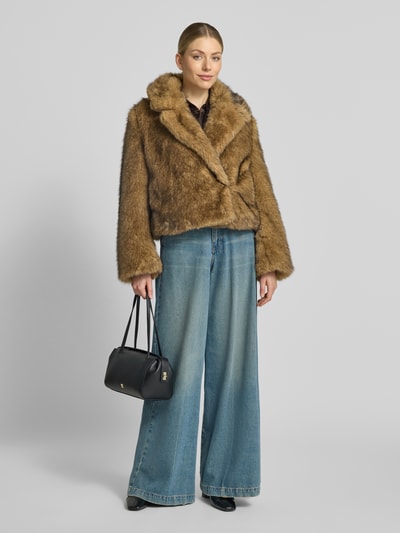 Frauenmodel trägt Jacke aus Kunstfell mit Reverskragen Modell 'ADWELL' von DRYKORN in Braun, kombiniert mit weiter Jeans, Ganzkörperansicht von vorne. Jacke mit Regular Fit, kuschelige Textur, Reverskragen, für Damen, Rückenlänge 55 cm, Schulterbreite 43 cm, Brustweite 54 cm, Ärmellänge 63 cm.