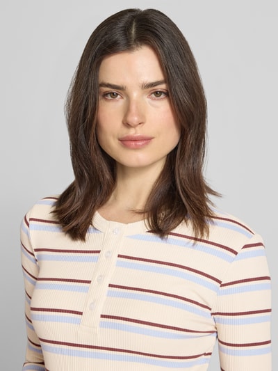Frauenmodel trägt Slim Fit Langarmshirt aus Baumwoll-Mix Modell 'KATIE' von Vero Moda mit Optik: mehrfarbig, Muster: Gestreift, Rundhals, Knopfleiste, Feinstrick, Nahaufnahme Oberkörper.