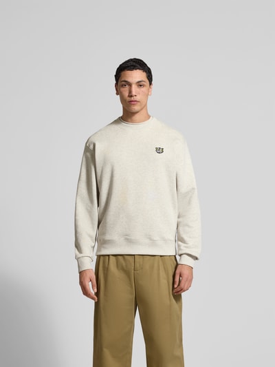 Männermodel trägt Sweatshirt aus reiner Baumwolle von Kenzo in Beige mit Label-Patch, lockerer Passform, elastische Abschlüsse, Ganzkörperansicht von vorne.