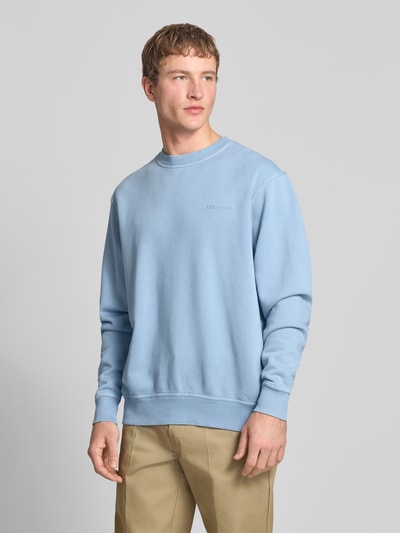 Mannelijk model draagt Sweatshirt mit Label-Stitching und Rundhalsausschnitt van Dickies in lichtblauw, relaxed fit, katoenmix, volledige lichaamsaanzicht van voren.
