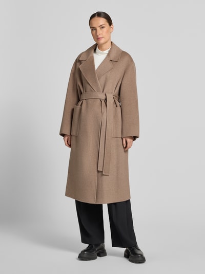 Frauenmodel trägt Mantel aus Wolle mit Bindegürtel von Milano Italy in Beige, Reverskragen, aufgesetzte Taschen, Regular Fit, Ganzkörperansicht von vorne.