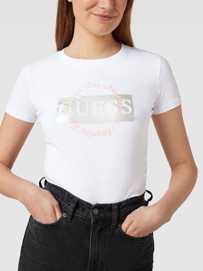 Guess T-shirt z nadrukiem z logo model ‘ROUND LOGO TEE’ Złamany biały 3