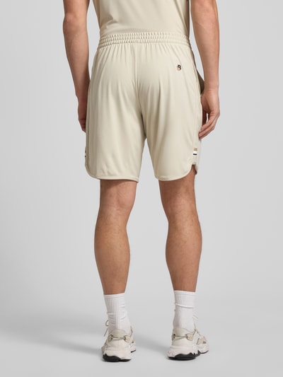 Männermodel trägt Regular Fit Shorts mit Label-Schriftzug Modell 'TOC SPIN 9 INCH' von BOSS Green, unifarben, elastischer Bund, seitliche Eingrifftaschen, Logo-Detail, Ganzkörperansicht Rückansicht.