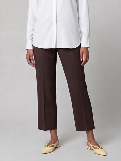 Frauenmodel trägt Regular Fit Culotte mit Bügelfalten Modell 'CAMERON' von CAMBIO in Dunkelbraun, glatte Stofftextur, Nahaufnahme Unterkörper. Damen Culotte von CAMBIO.