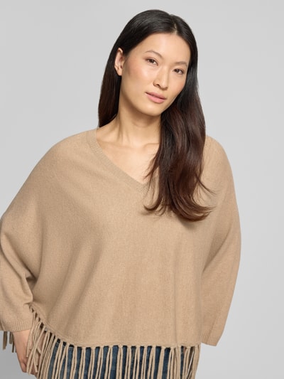Frauenmodel trägt Relaxed Fit Pullover aus Woll-Mix mit Kaschmir-Anteil von HERZENS, beigefarbene Strick-Optik, Fransen-Abschluss, Nahaufnahme Oberkörper.