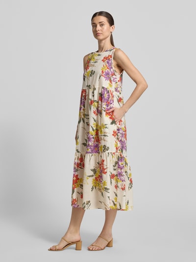 Vrouwenmodel draagt midi-jurk van puur katoen met bloemenprint, loose fit, ronde hals, volantzoom, model 'TABARIN' van EMME, ruglengte maat 36 35 cm, borstwijdte 46 cm, druppelvormige hals achter, volledige lichaamsvooraanzicht.