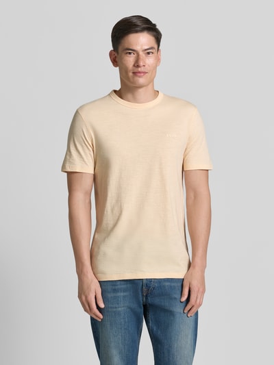 Männermodel trägt Regular Fit T-Shirt aus reiner Baumwolle Modell 'TEGOOD' von BOSS Orange, unifarben mit Logo-Print, Ganzkörperansicht von vorne.