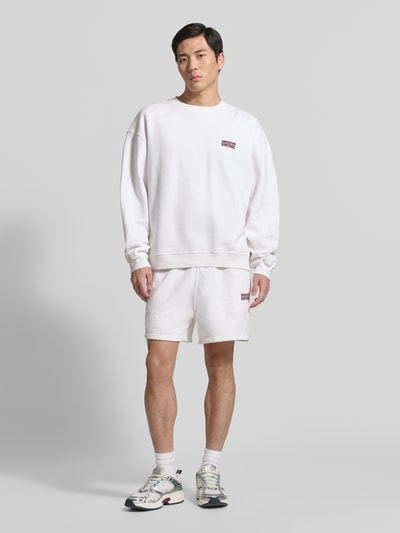 Männermodel trägt Shorts mit Logo Modell 'PLIZZY' von American Vintage aus Reine Baumwolle, Relaxed-Fit, Logo, Tunnelzug, Ganzkörperansicht von vorne.