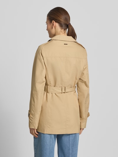 Kobiece model prezentuje Regular Fit Trenchcoat aus Baumwoll-Mix od s.Oliver RED LABEL, beżowy twill, dłuższy fason, widok całej sylwetki z tyłu.
