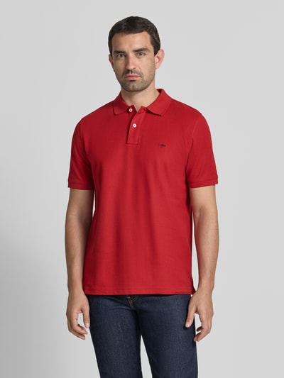 Männermodel trägt Regular Fit Poloshirt mit Label-Stitching von Fynch-Hatton aus Reine Baumwolle, rote Farbe, Knopfleiste, Rückenlänge 72 cm bei Größe M, Ganzkörperansicht von vorne.