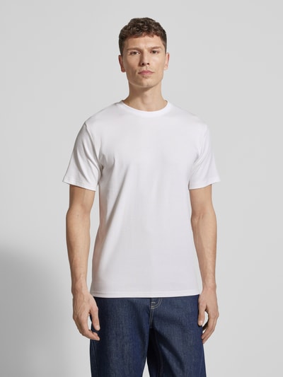 Männermodel trägt Regular Fit T-Shirt aus Baumwoll-Mix Modell 'SPENCER' von SELECTED HOMME, weiß, fein gerippte Struktur, Ganzkörperansicht von vorne.
