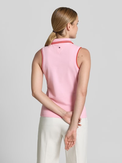 Frauenmodel trägt Slim Fit Poloshirt aus Baumwoll-Mix von Tommy Hilfiger in Two Tone Optik mit Kontrastnähten und Logo, Ganzkörperansicht Rückansicht.