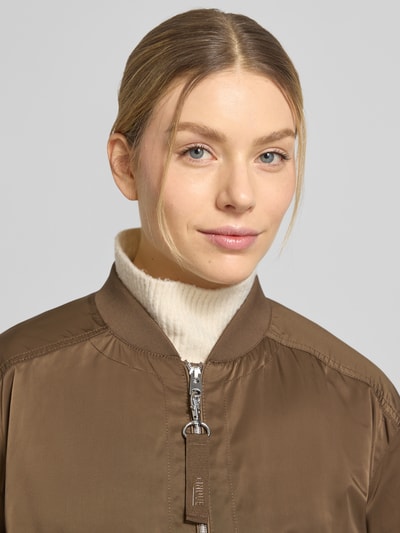 Frauenmodel trägt Jacke mit Pattentaschen Modell 'CIBLOUMINA' von CINQUE in Braun mit Stehkragen und Reißverschluss, Nahaufnahme Oberkörper.