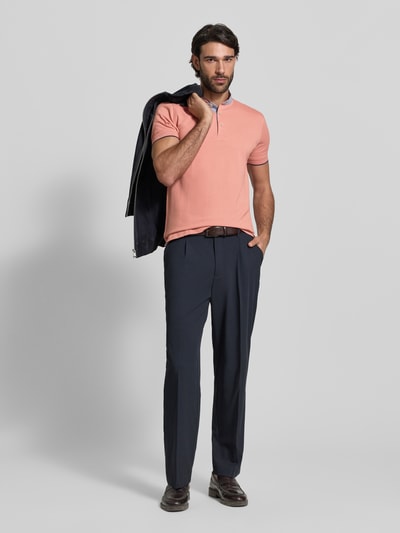 Männermodel trägt Regular Fit Poloshirt aus reiner Baumwolle mit Stehkragen von Christian Berg Men, lachsfarben, Kurzarm, Ganzkörperansicht von vorne.