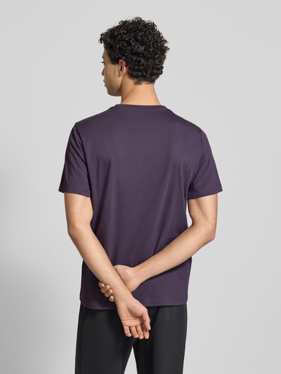 Männermodel trägt Regular Fit T-Shirt aus bawełnianego miksu Modell 'EVOLUTION' von The North Face, kolor ciemnofioletowy, gładka struktura, krój regular fit, okrągły dekolt, detal z logo, długość tyłu w rozmiarze M: 71 cm, Ganzkörperansicht Rückansicht.