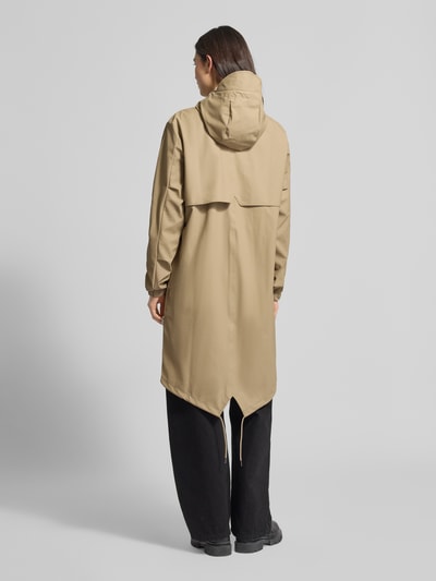 Frauenmodel trägt Regular Fit Parker mit Kapuze Modell 'Fishtail' von Rains in Beige, Pattentaschen, elastische Ärmelabschlüsse, Rückenlänge 104 cm, Schulterbreite 45 cm, Brustweite 55 cm, Ärmellänge 65 cm, Ganzkörperansicht Rückansicht.