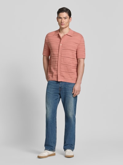 Männermodel trägt Regular Fit Strickjacke aus reiner Baumwolle Modell 'PALLE' von SELECTED HOMME in Rosa, Strukturmuster, Ganzkörperansicht von vorne.