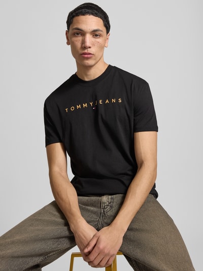 Männermodel trägt Regular Fit T-Shirt aus reiner Baumwolle von Tommy Jeans, Optik: Unifarben, Label-Stitching, Nahaufnahme Oberkörper.