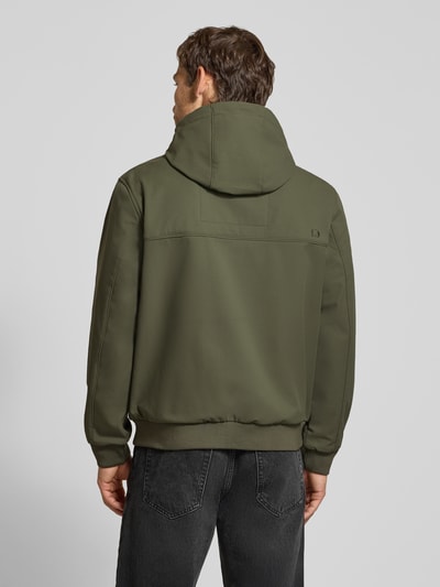 Männermodel trägt Regular Fit Funktionsjacke mit Kapuze von Tom Tailor Denim in Olivgrün, glatte Textur, Ganzkörperansicht Rückansicht. Herren Funktionsjacke von Tom Tailor Denim.