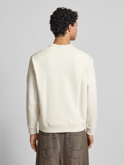 Męski model nosi Sweatshirt aus reiner Baumwolle od Calvin Klein Jeans, kremowy kolor, prosty krój, widok całej sylwetki z tyłu.