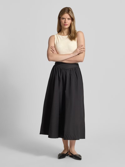 Kobiece model nosi Slim Fit Top mit floralem Allover-Stitching Modell 'Jacquard' von Gina Tricot, elastyczna mieszanka materiałów, krój slim fit, długość tyłu w rozmiarze S: 47 cm, jasny beż z delikatnym kwiatowym haftem, całkowity widok z przodu.