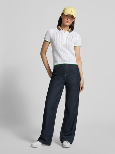 Modelka nosi Regular Fit Strick-Poloshirt aus Baumwoll-Mix von Polo Ralph Lauren, efekt: jednolity kolor, z paskami w kontrastowym kolorze, kołnierzyk polo, krótki rękaw, zakończenie rękawów i wykończenie prążkowane, dzianina, mieszanka bawełny. Ganzkörperansicht von vorne.