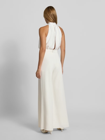 Frauenmodel trägt Jumpsuit mit Stehkragen von SWING aus elastischem Material-Mix, tailliert, ärmellos, Zierschleife, Ganzkörperansicht Rückansicht.